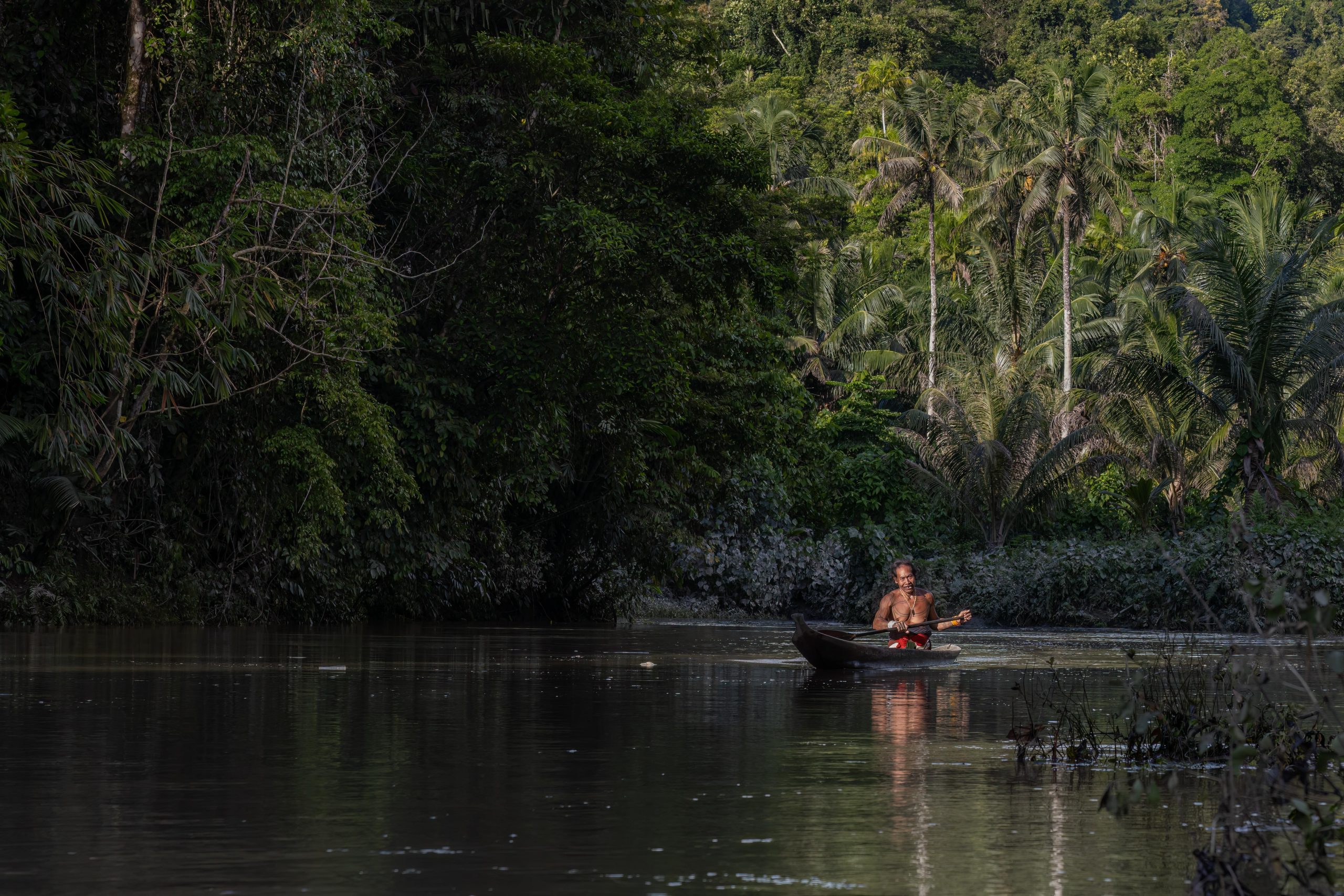 Mentawai shaman in canoe on Siberut Island, Sumatra, Indonesia